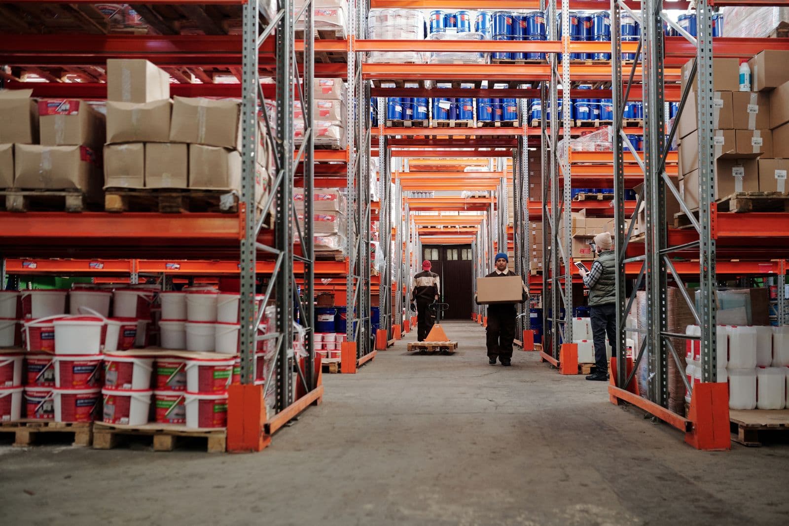 Workers organizing cartons from different suppliers in a consolidation warehouse