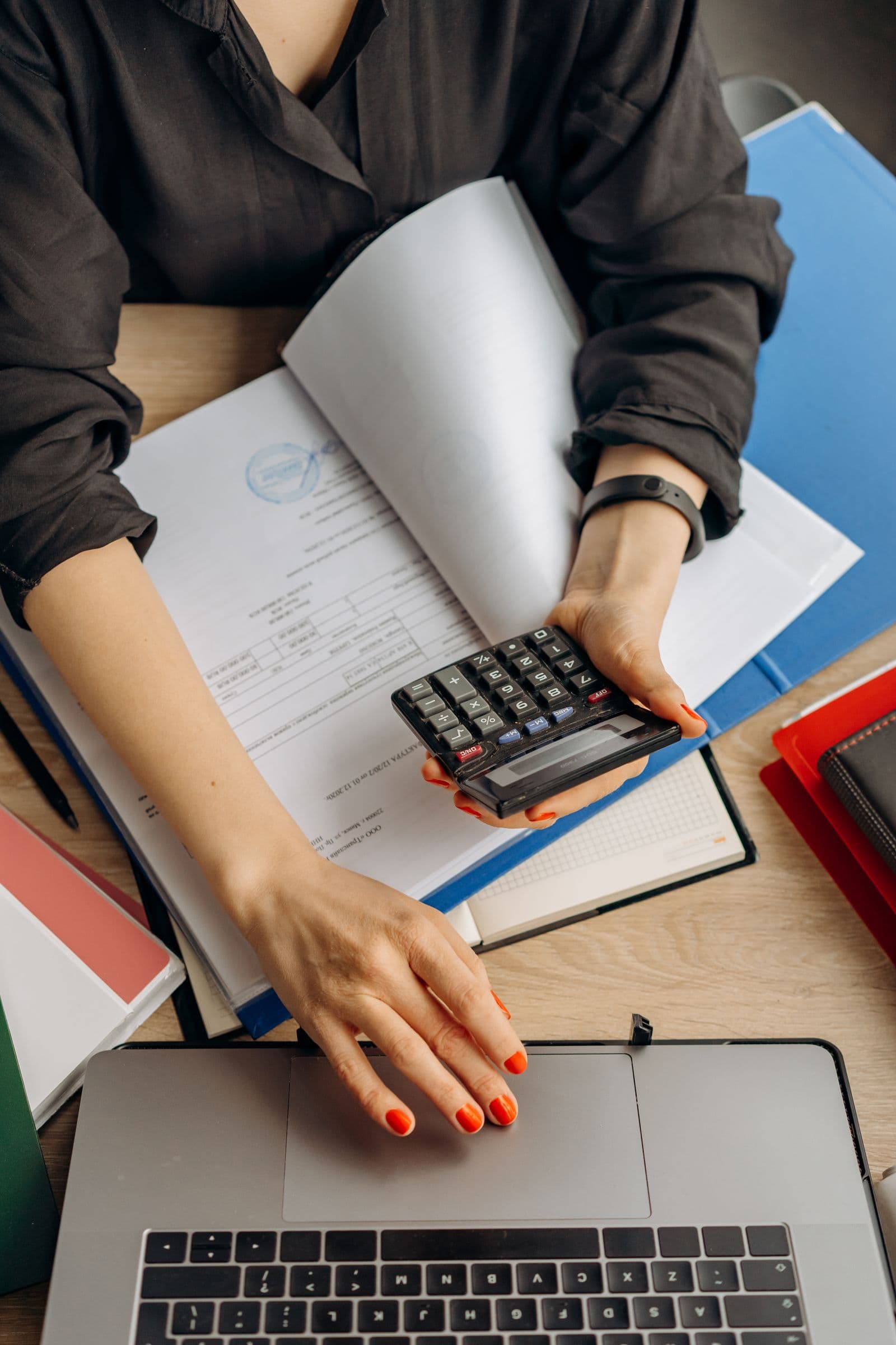 Buyer comparing supplier quotations with a calculator and written records